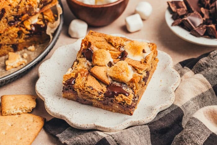 A slice of s'mores blondies on a white plate.