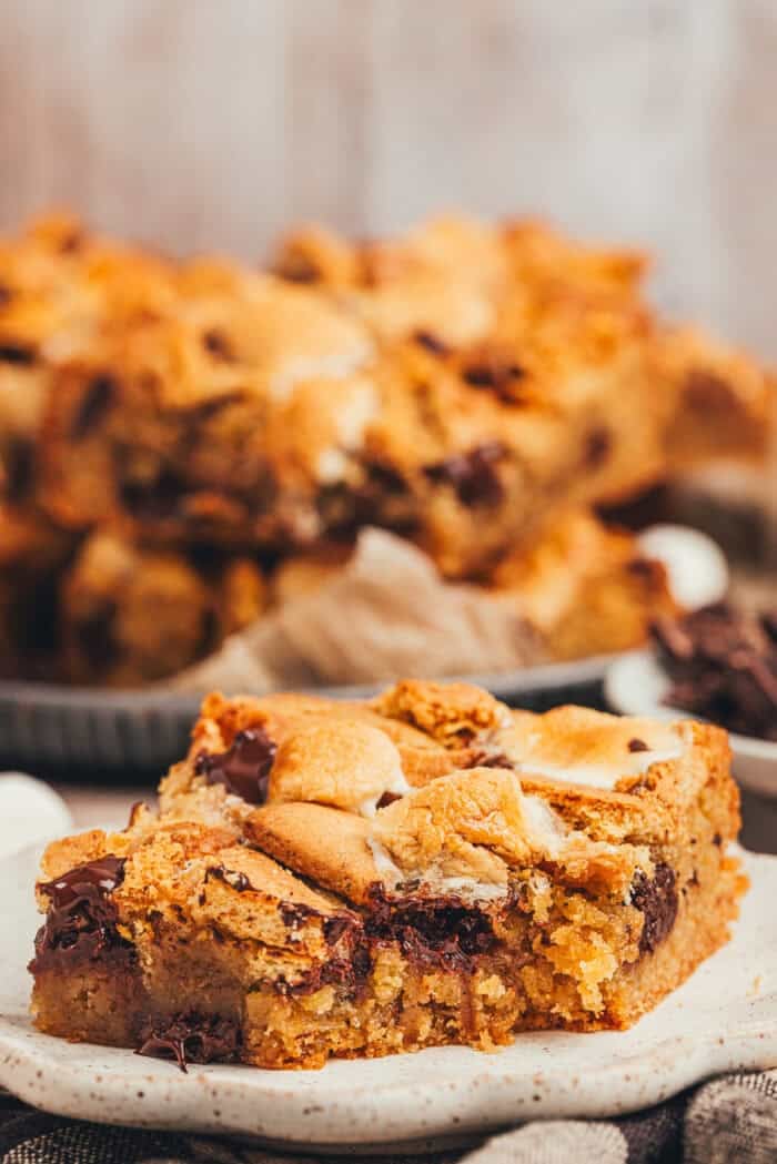 A slice of s'mores blondies on a white plate.
