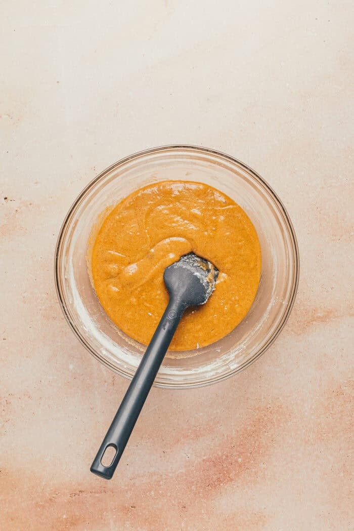 The s'mores bar batter in a glass bowl with a spatula.