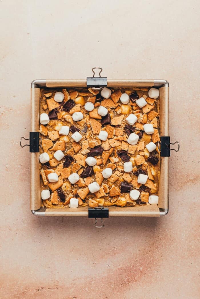 The unbaked s'mores in a baking pan with extra marshmallows and chocolate chips.