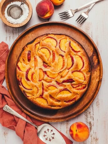 The top view of a peach cake showing the sliced peaches on a platter.