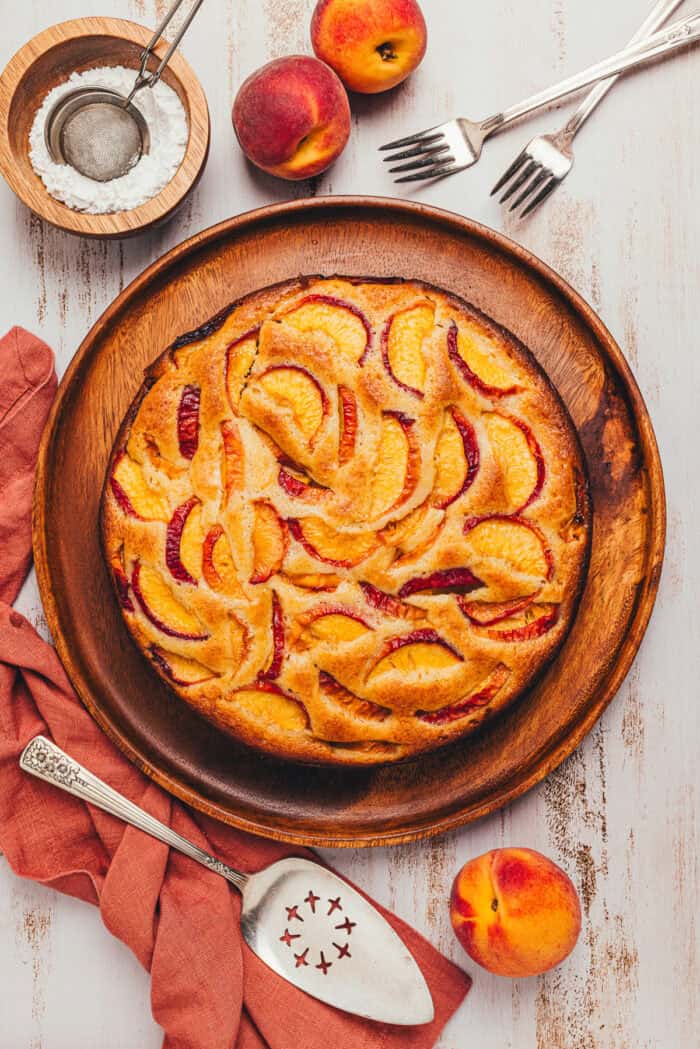 The top view of a peach cake showing the sliced peaches on a platter.
