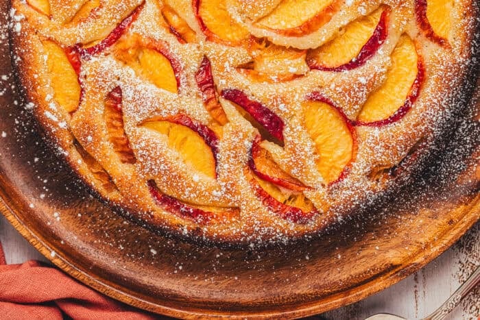 The top view of a peach cake showing the sliced peaches on a platter.