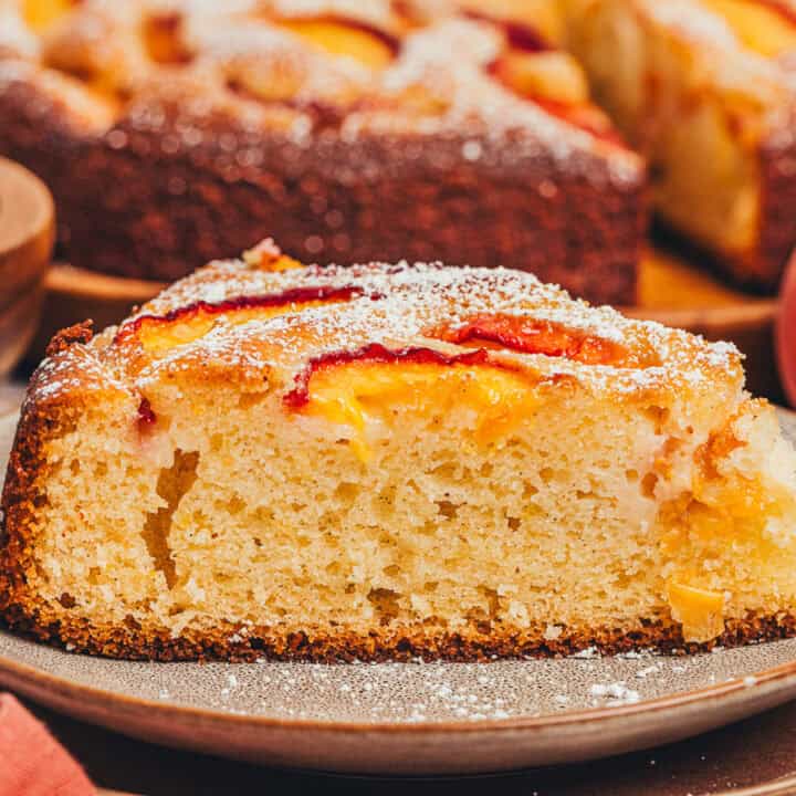 A slice of homemade peach cake on a plate.