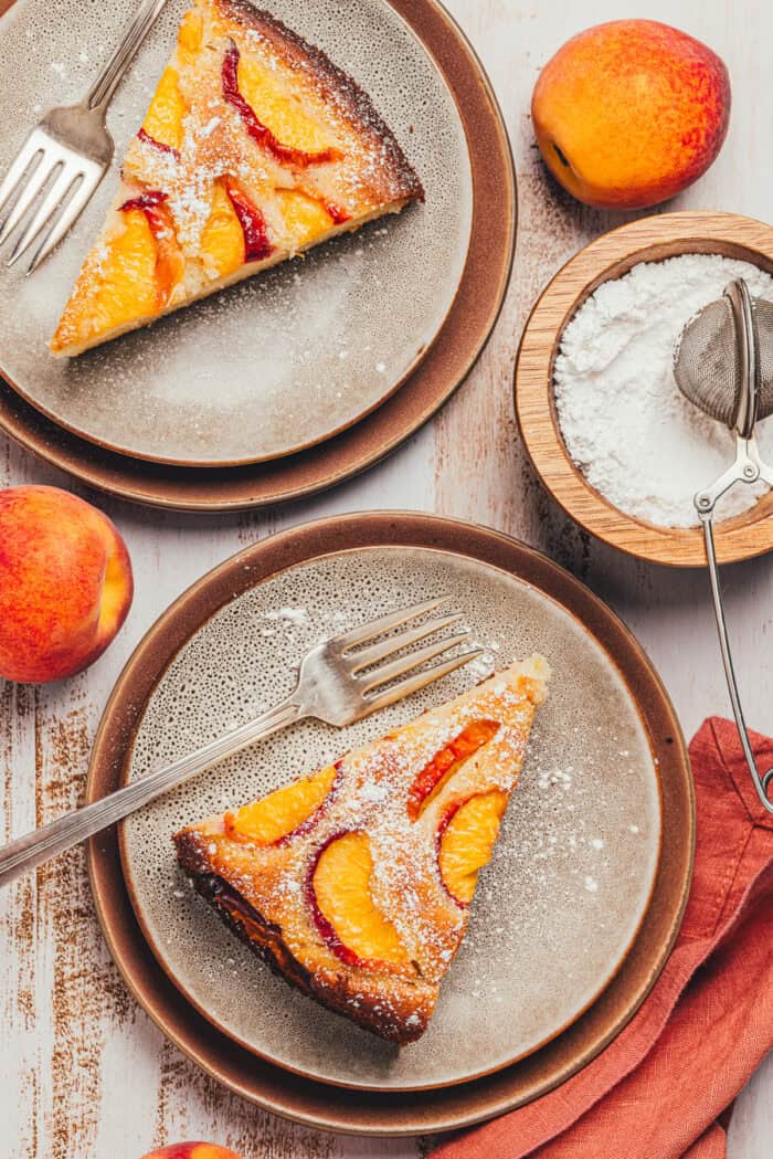Two plates with a slice of peach snack cake.