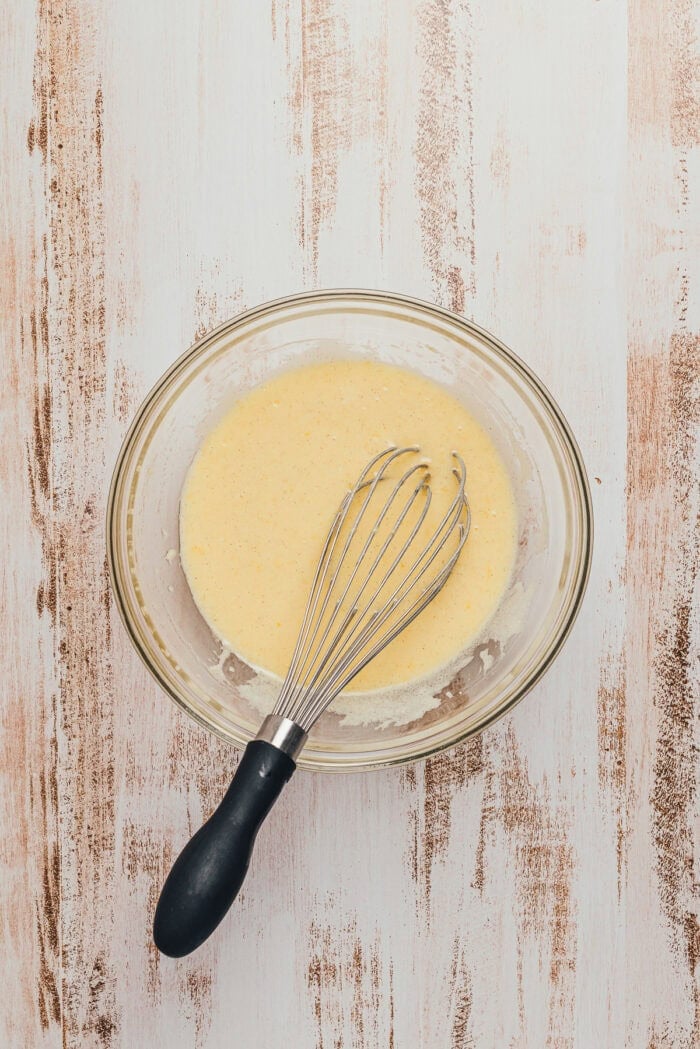 A glass bowl with the wet ingredients mixed together.