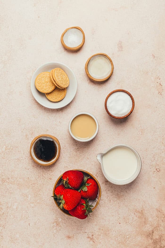 The ingredients needed to make homemade strawberry cookies and cream ice cream.