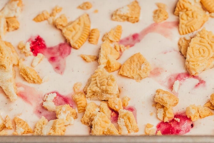 Upclose showing the top of the ice cream with vanilla cookies and strawberry chunks.