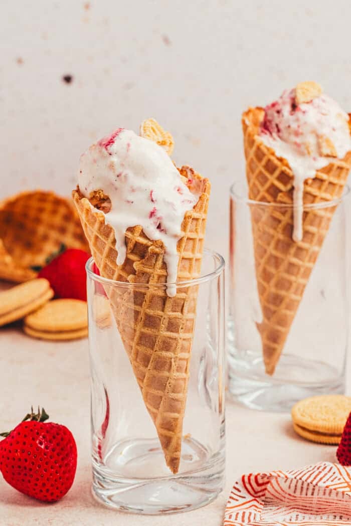 Two ice cream cones filled with homemade strawberry cookies and cream ice cream.