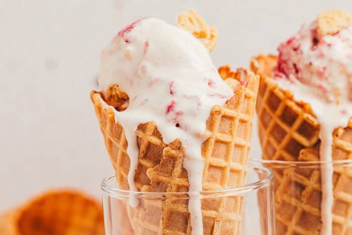 Two ice cream cones filled with homemade strawberry cookies and cream ice cream.