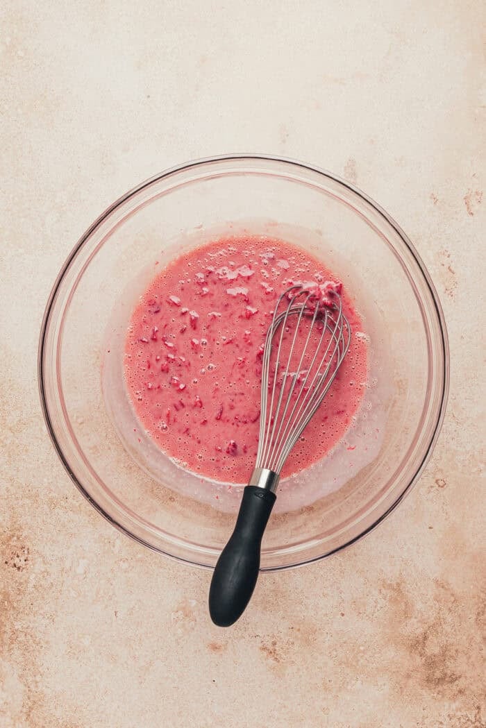 A glass bowl with cookies strawberries mixed with condensed milk.