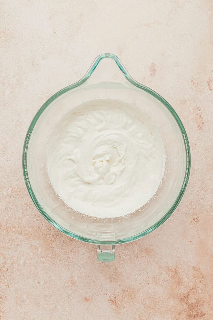 Heavy whipping cream in a large glass mixing bowl