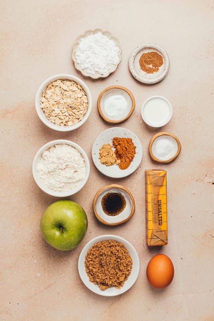 Various bowls with the ingredients for cinnamon apple oatmeal cookies.
