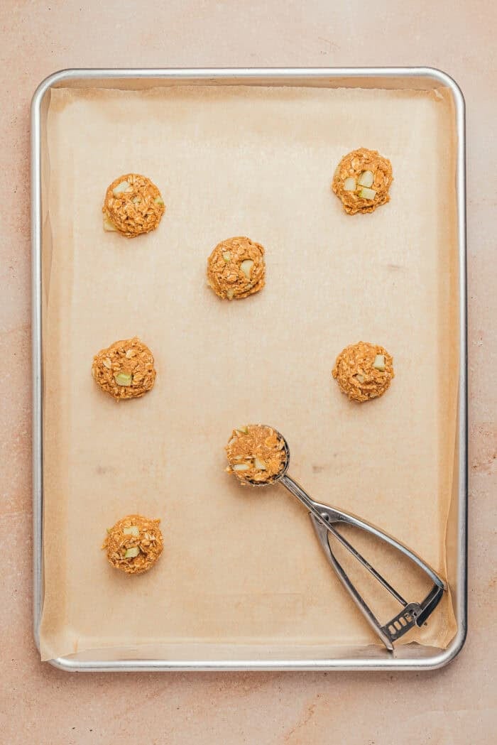 The unbaked oatmeal cookies on a cookie tray.