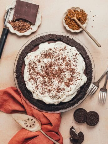 A no bake chocolate pie in a pie plate with smaller plates filled with garnishes.