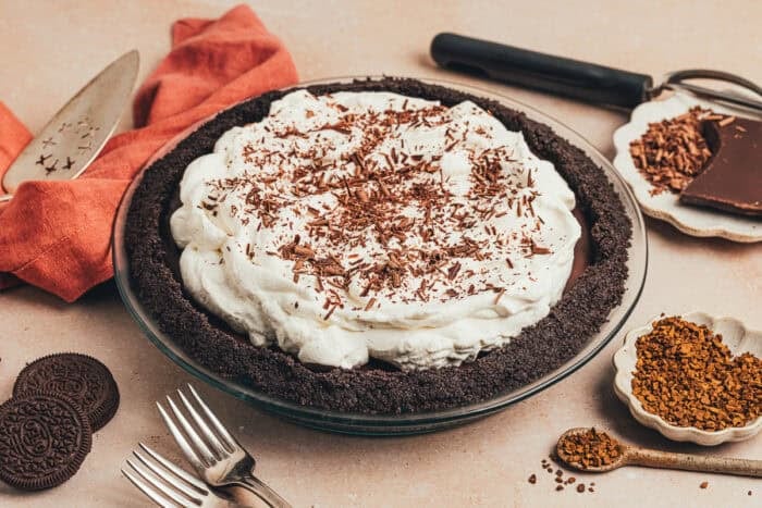 A whole no bake chocolate espresso pie with a napkin and serving utensils.