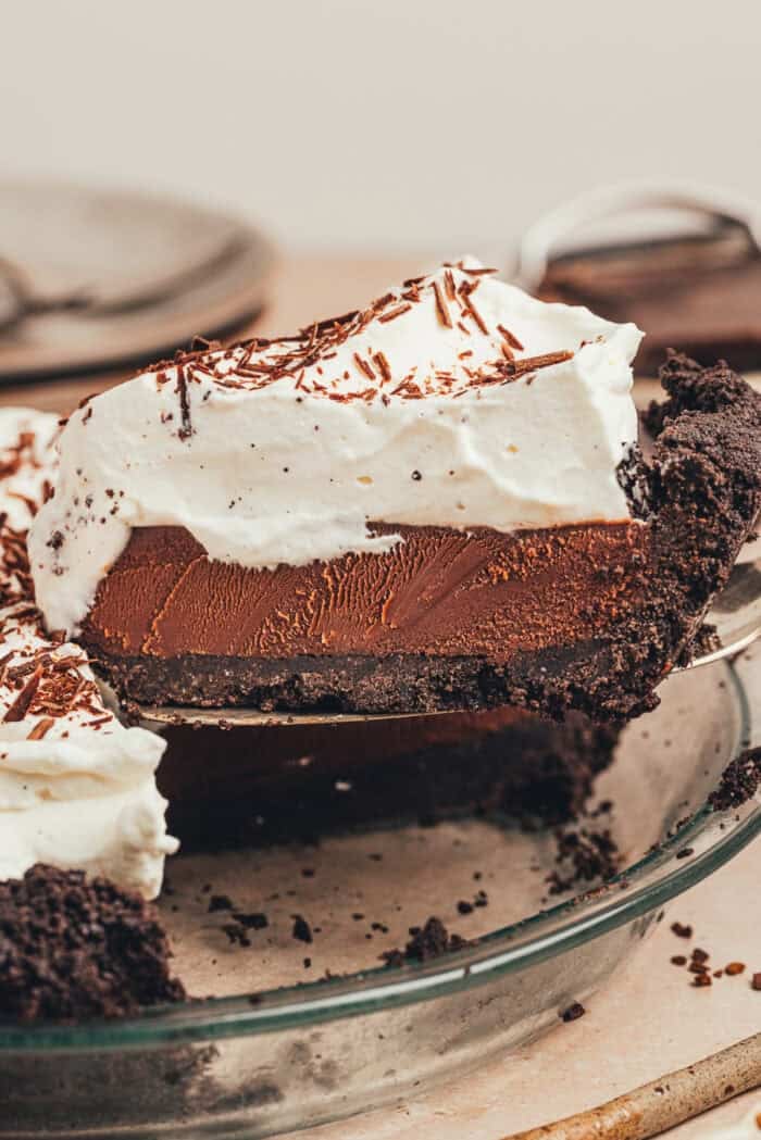 A whole no bake chocolate espresso pie with a slice of it being removed.
