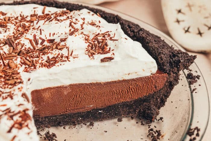 Part of a no bake espresso chocolate pie in a pie plate with a few pieces removed.