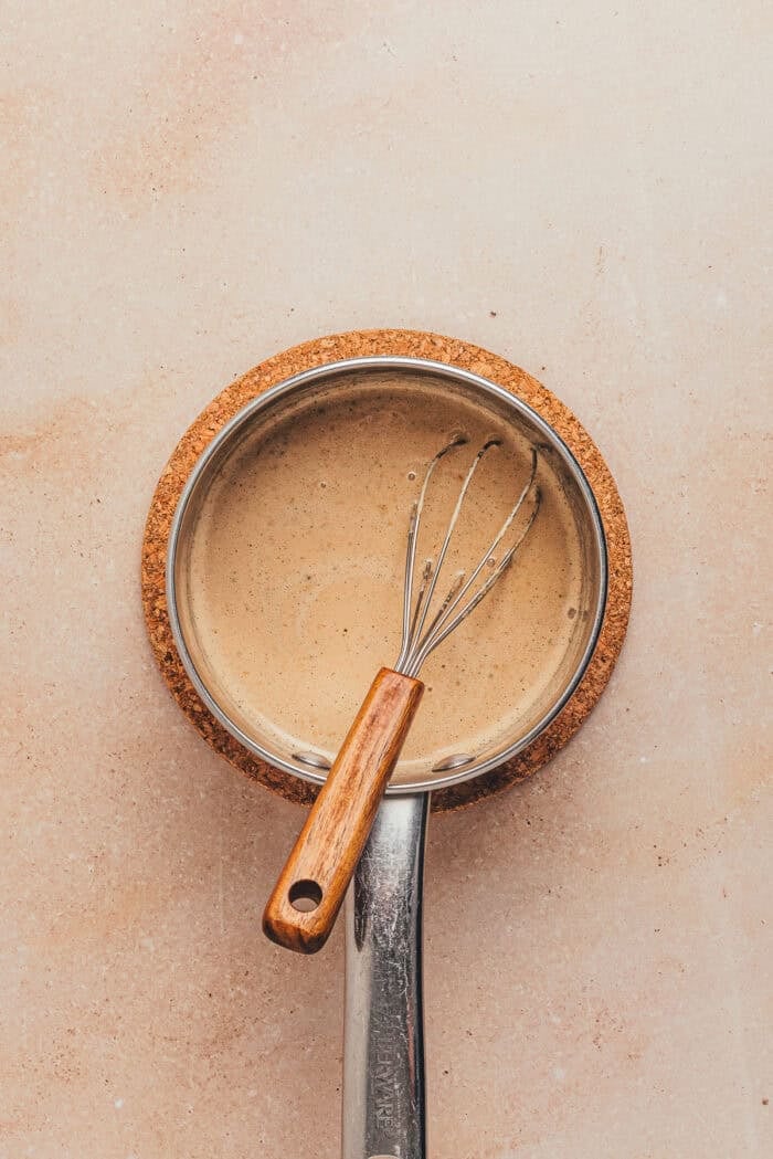 The heated cream with the espresso combined and a whisk.