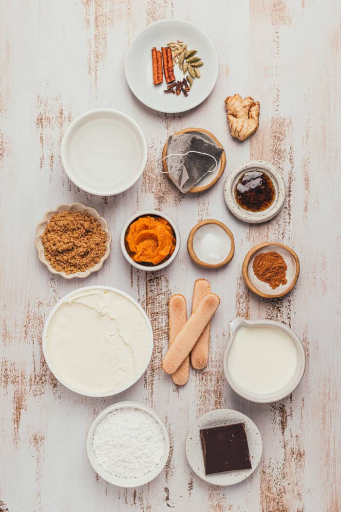 Mascarpone, pumpkin puree, ladyfingers, and whole chai spices arranged on a counter