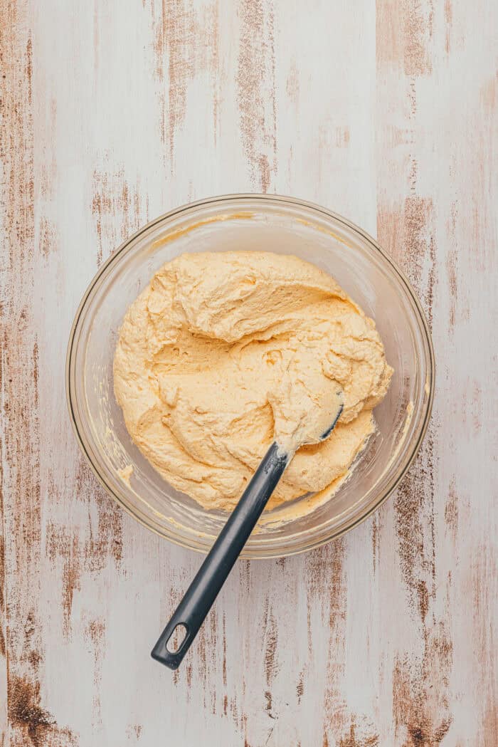 Fluffy pumpkin spice mascarpone cream being folded together in a mixing bowl