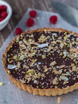 A decadent gluten free and vegan chocolate coconut tart that starts with a chewy coconut almond crust and is filled with creamy chocolate coconut ganache.