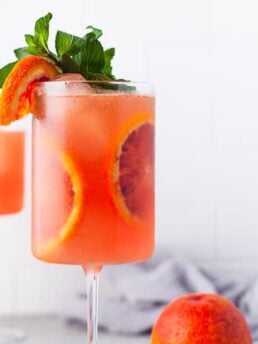Blood orange cocktail in a glass with blood orange slices.