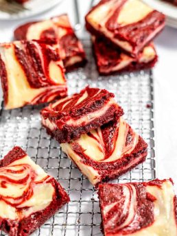 Red velvet cheesecake brownies on a cooling rack.