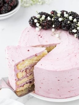 Blackberry layer cake with a slice removed.