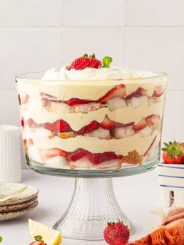 A strawberry trifle in a trifle bowl showing all of the layers.