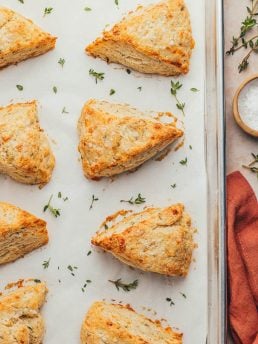 Baked thyme scones on a parchment-lined baking sheet.