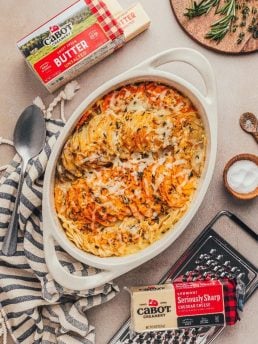 Packages of Cabot cheese and a white baking dish filled with the root vegetable gratin.