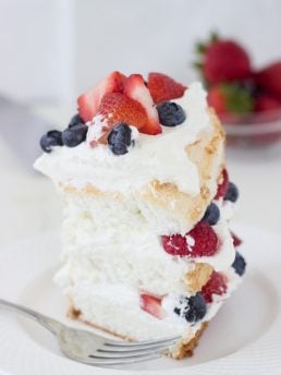 This classic angel food cake recipe is filled with homemade dairy-free coconut whipped cream and studded with berries for a pretty 4th of July look!